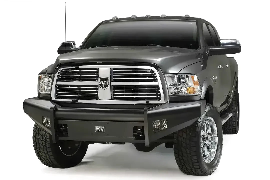 Fab Fours Black Steel Elite front bumper on a gray Ram 2500, front three-quarter view, showing the center tube, Elite badge and mesh-covered light openings