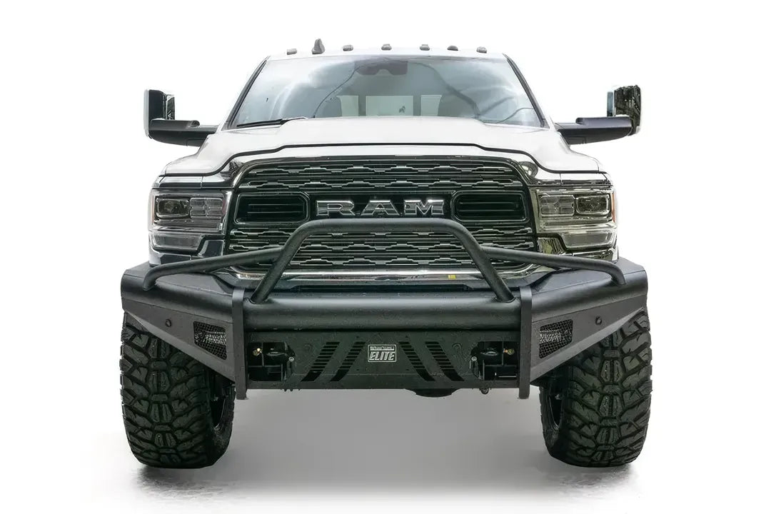 Fab Fours Black Steel Elite front bumper with pre-runner guard on a white lifted Ram 2500, straight-on front view, showing the pre-runner hoop, Elite badge and slotted skid plate