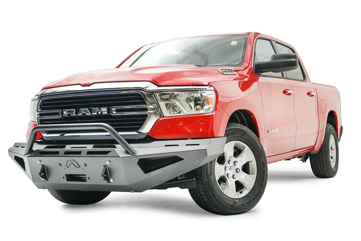 Fab Fours Red Steel front bumper with pre-runner guard on a red Ram 1500, front driver-side three-quarter view, showing the pre-runner hoop, shackle mounts and vented end panel