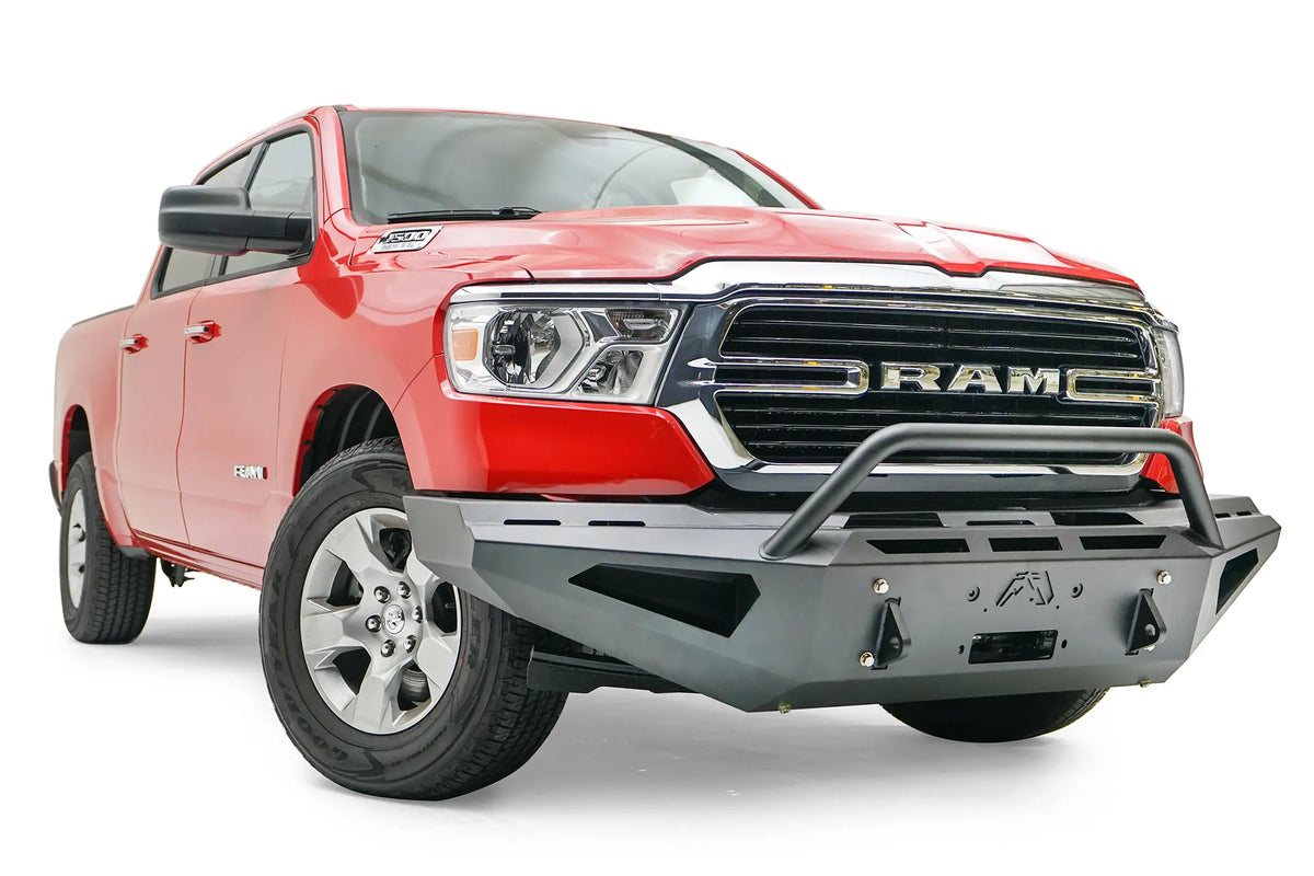 Fab Fours Red Steel front bumper with pre-runner guard on a red Ram 1500, front passenger-side three-quarter view, showing the pre-runner hoop, shackle mounts and vented end panel