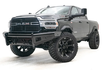 Fab Fours Black Steel front bumper on a black lifted Ram 2500, front driver-side three-quarter view, showing the diamond-plate wings, center tube and mesh light openings