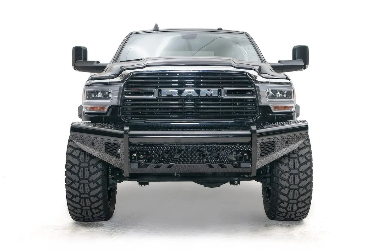Fab Fours Black Steel front bumper on a black lifted Ram 2500, straight-on front view, showing the diamond-plate face, center tube and mesh light openings