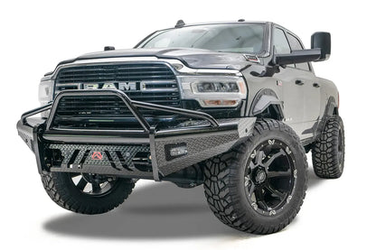 Fab Fours Black Steel front bumper with pre-runner guard on a black lifted Ram 2500, front driver-side three-quarter view, showing the pre-runner hoop, diamond-plate wings and red logo badge