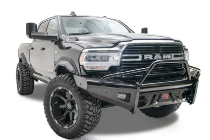 Fab Fours Black Steel front bumper with pre-runner guard on a black lifted Ram 2500, front passenger-side three-quarter view, showing the pre-runner hoop, diamond-plate face and red logo badge