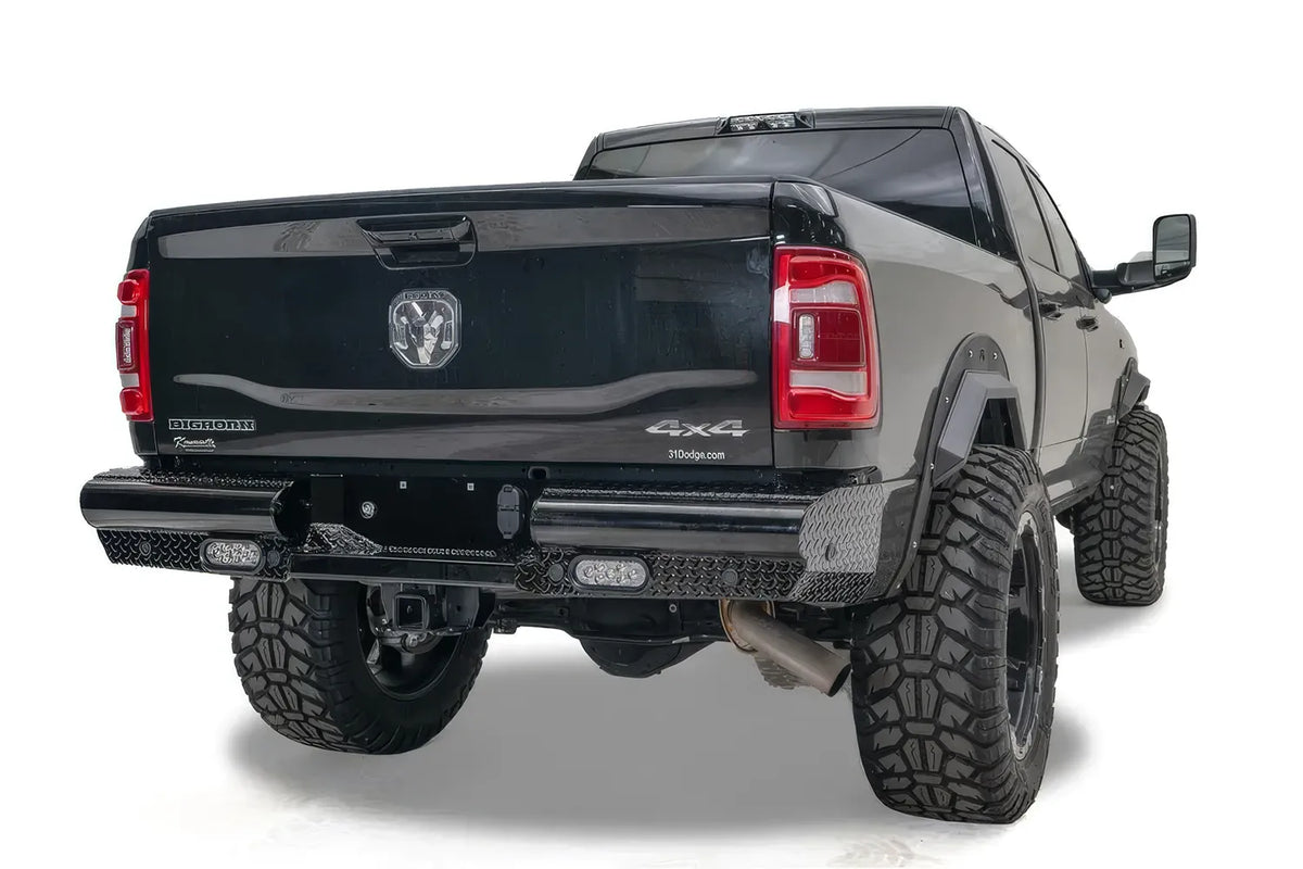 Fab Fours Black Steel rear bumper with diamond plate on a lifted black Ram 2500, rear three-quarter view