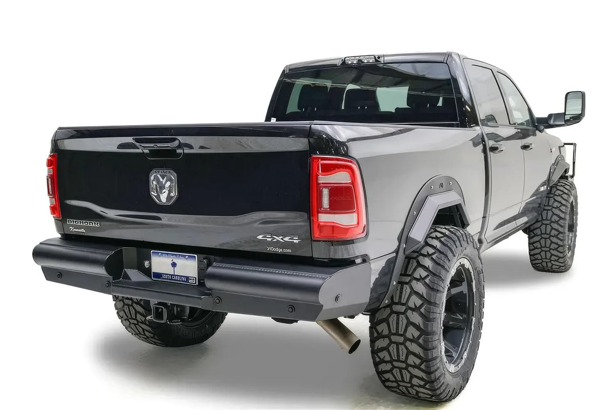 Fab Fours Black Steel Elite rear bumper on a black lifted Ram 2500, rear passenger-side three-quarter view, showing the tube bumper, plate mount and wrap-around end