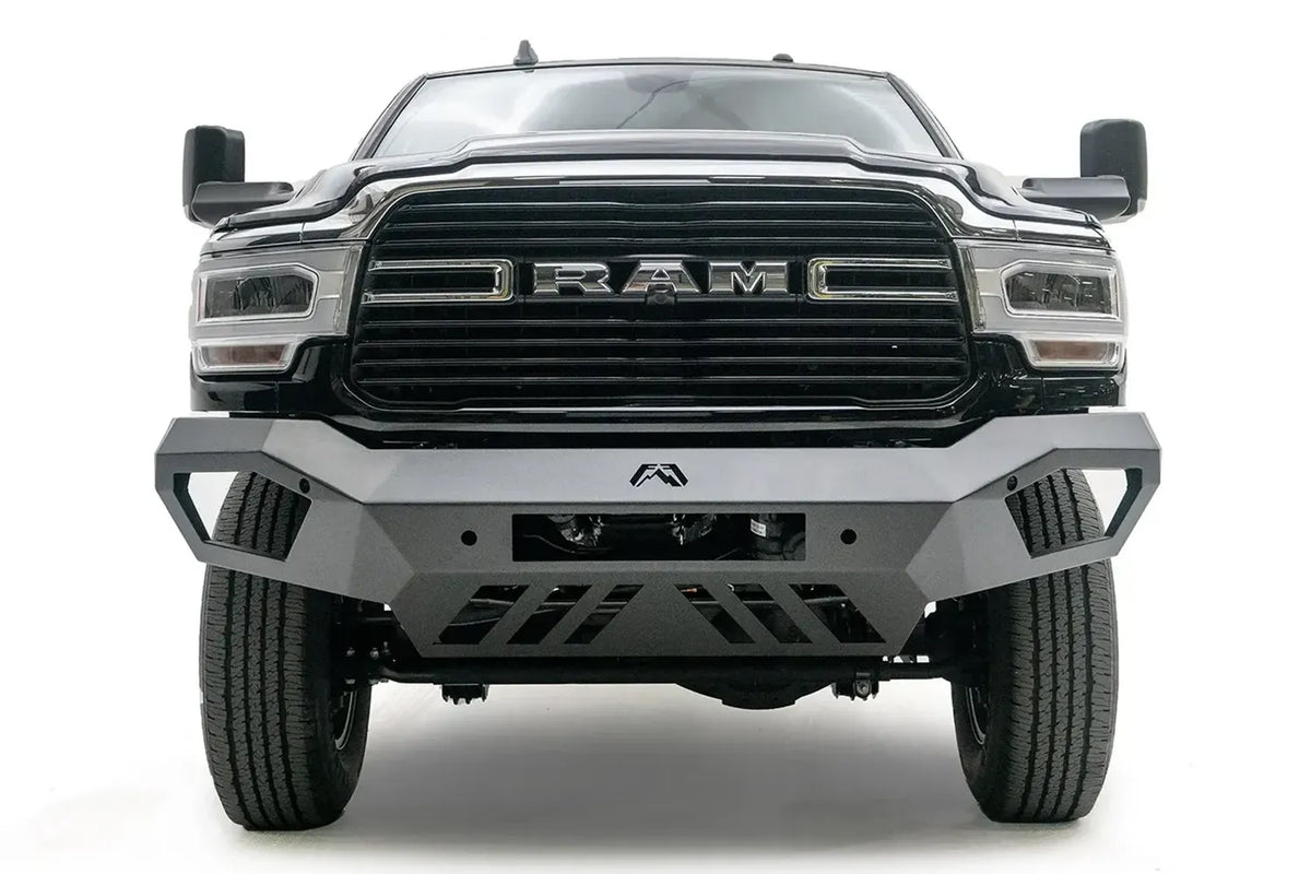 Fab Fours Vengeance front bumper on a black Ram 2500, straight-on front view, showing the angled wings, center logo, light bar opening and slotted skid plate