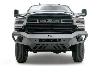 Fab Fours Vengeance front bumper on a black Ram 2500, straight-on front view, showing the angled wings, center logo, light bar opening and slotted skid plate