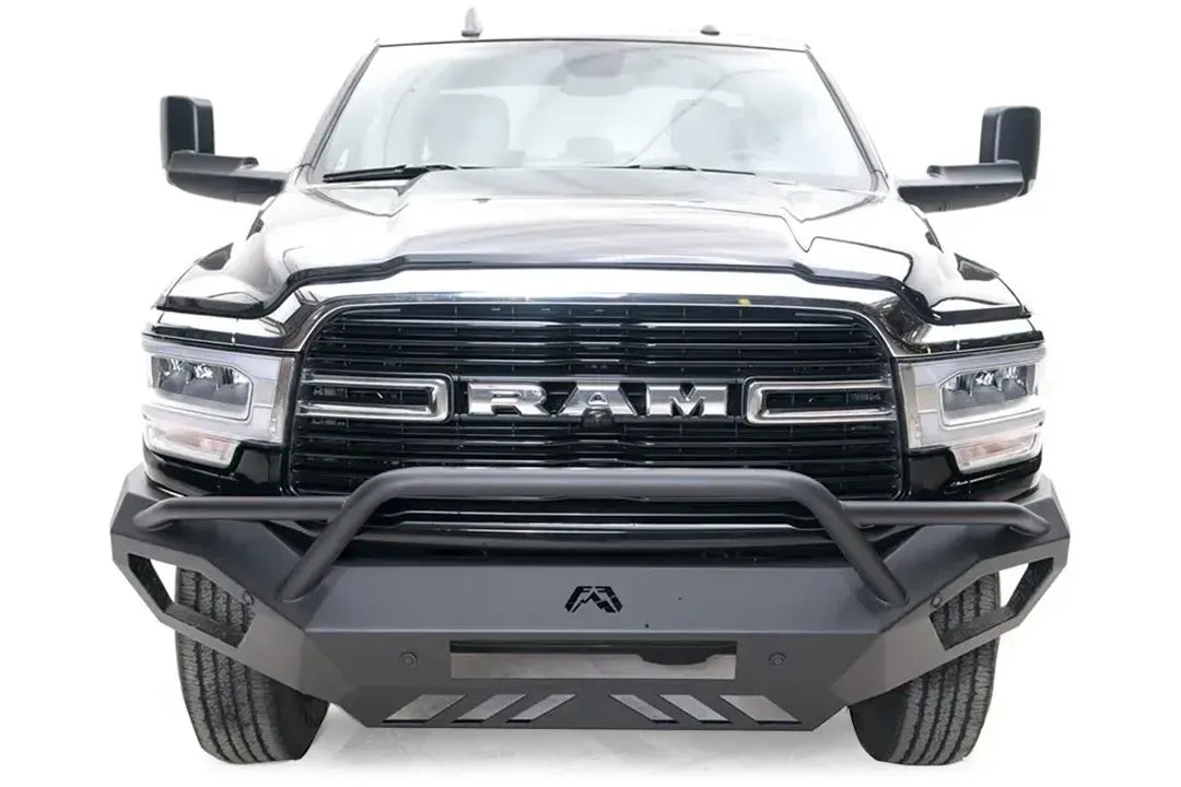 Fab Fours Vengeance front bumper with pre-runner guard on a black Ram 2500, straight-on front view, showing the pre-runner hoop, center logo and slotted skid plate
