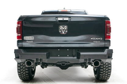 Fab Fours Premium rear bumper on a dark gray lifted Ram 1500, straight-on rear view, showing the dual exhaust cutouts, center plate area and receiver hitch access