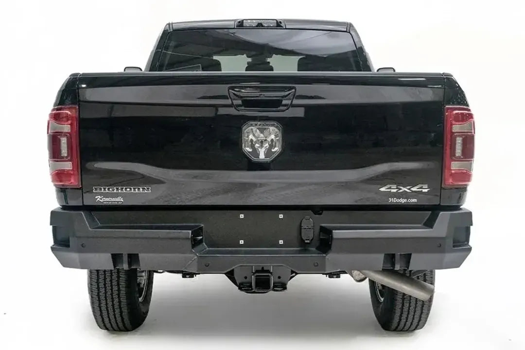 Fab Fours Premium rear bumper on a black Ram 2500, straight-on rear view, showing the center plate area, sensor ports and receiver hitch access
