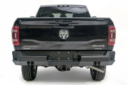 Fab Fours Premium rear bumper on a black Ram 2500, straight-on rear view, showing the center plate area, sensor ports and receiver hitch access