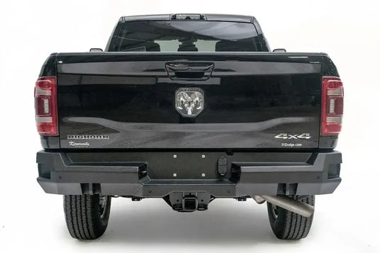 Fab Fours Premium rear bumper on a black Ram 2500, straight-on rear view, showing the center plate area, sensor ports and receiver hitch access