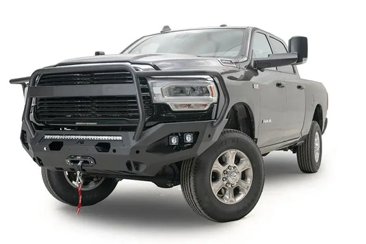 Fab Fours Matrix front bumper with full guard on a dark gray Ram 2500, front driver-side three-quarter view, showing the full grille guard, integrated light bar, cube lights and winch