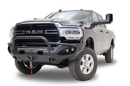 Fab Fours Matrix front bumper with pre-runner guard on a black Ram 2500, front driver-side three-quarter view, showing the pre-runner hoop, integrated light bar and winch
