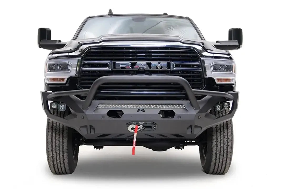 Fab Fours Matrix front bumper with pre-runner guard on a black Ram 2500, straight-on front view, showing the pre-runner hoop, integrated light bar, cube lights and winch