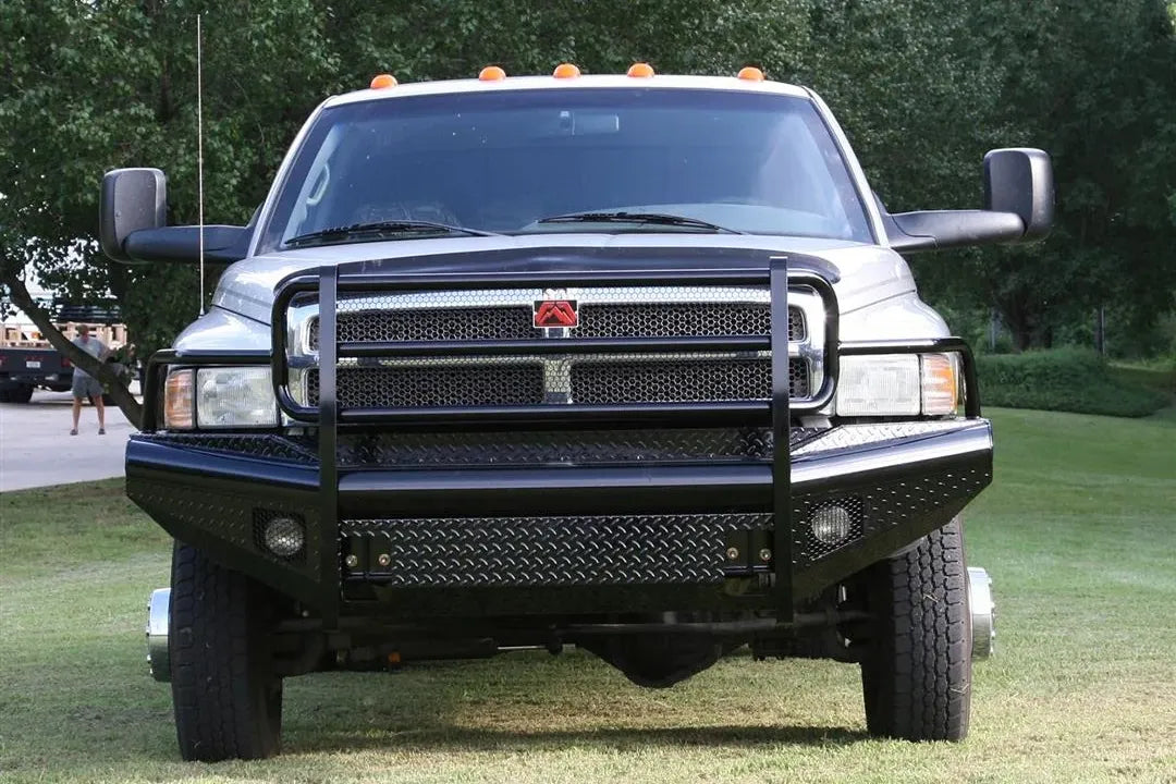 Fab Fours Black Steel front ranch bumper with full guard on a silver Ram 2500, straight-on front view outdoors, showing the full-width grille guard, diamond-plate bumper face and fog light openings