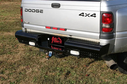 Fab Fours Black Steel Ranch rear bumper with diamond plate on a silver Dodge Ram dually, rear three-quarter view