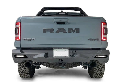 Fab Fours Vengeance rear bumper on a gray Ram 1500 TRX, straight rear view, with LED light bars installed in the corner openings, center license plate mount, and hitch receiver