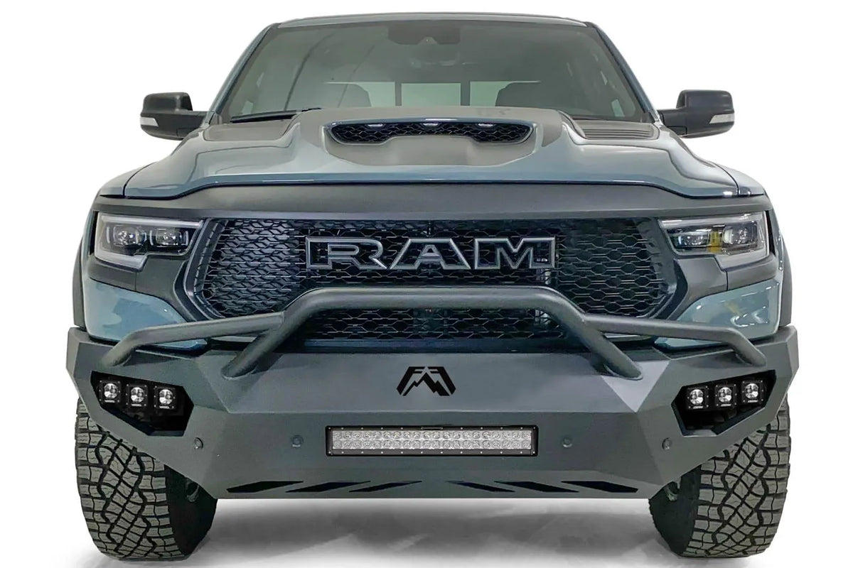 Fab Fours Vengeance front bumper with pre-runner guard on a gray Ram 1500 TRX, straight-on front studio view, showing the pre-runner hoop, center light bar and cube light pods
