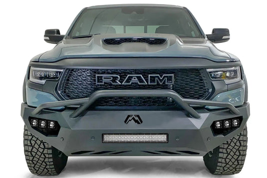 Fab Fours Vengeance front bumper with pre-runner guard on a gray Ram 1500 TRX, straight-on front studio view, showing the pre-runner hoop, center light bar and cube light pods