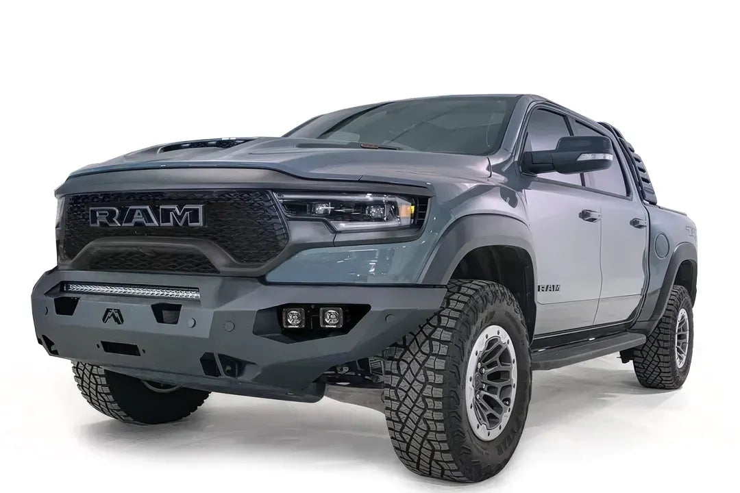 Fab Fours Matrix front bumper on a gray Ram 1500 TRX, front driver-side three-quarter studio view, showing the full-width bumper, top light bar and cube light pods