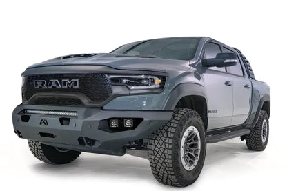 Fab Fours Matrix front bumper on a gray Ram 1500 TRX, front driver-side three-quarter studio view, showing the full-width bumper, top light bar and cube light pods