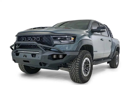 Fab Fours Matrix front bumper with pre-runner guard on a gray Ram 1500 TRX, front driver-side three-quarter studio view, showing the pre-runner hoop, top light bar and cube light pods