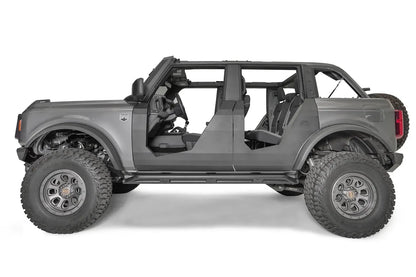 Fab Fours Trail Doors on a lifted gray four-door Ford Bronco, driver-side profile, showing the clean matte black steel doors with open upper sections and Fab Fours logo
