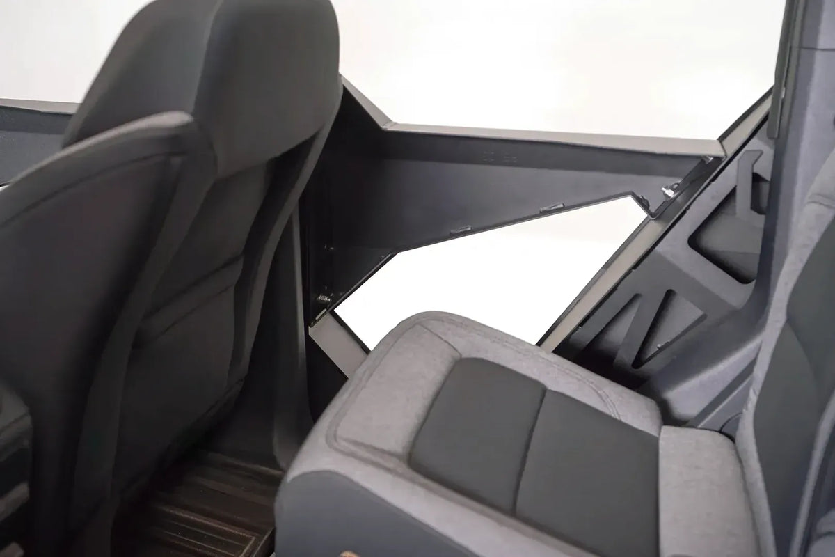 Interior view of a Fab Fours Trail Door Insert on a Ford Bronco rear door, showing the bolted steel panel and angled cutout beside the rear seat