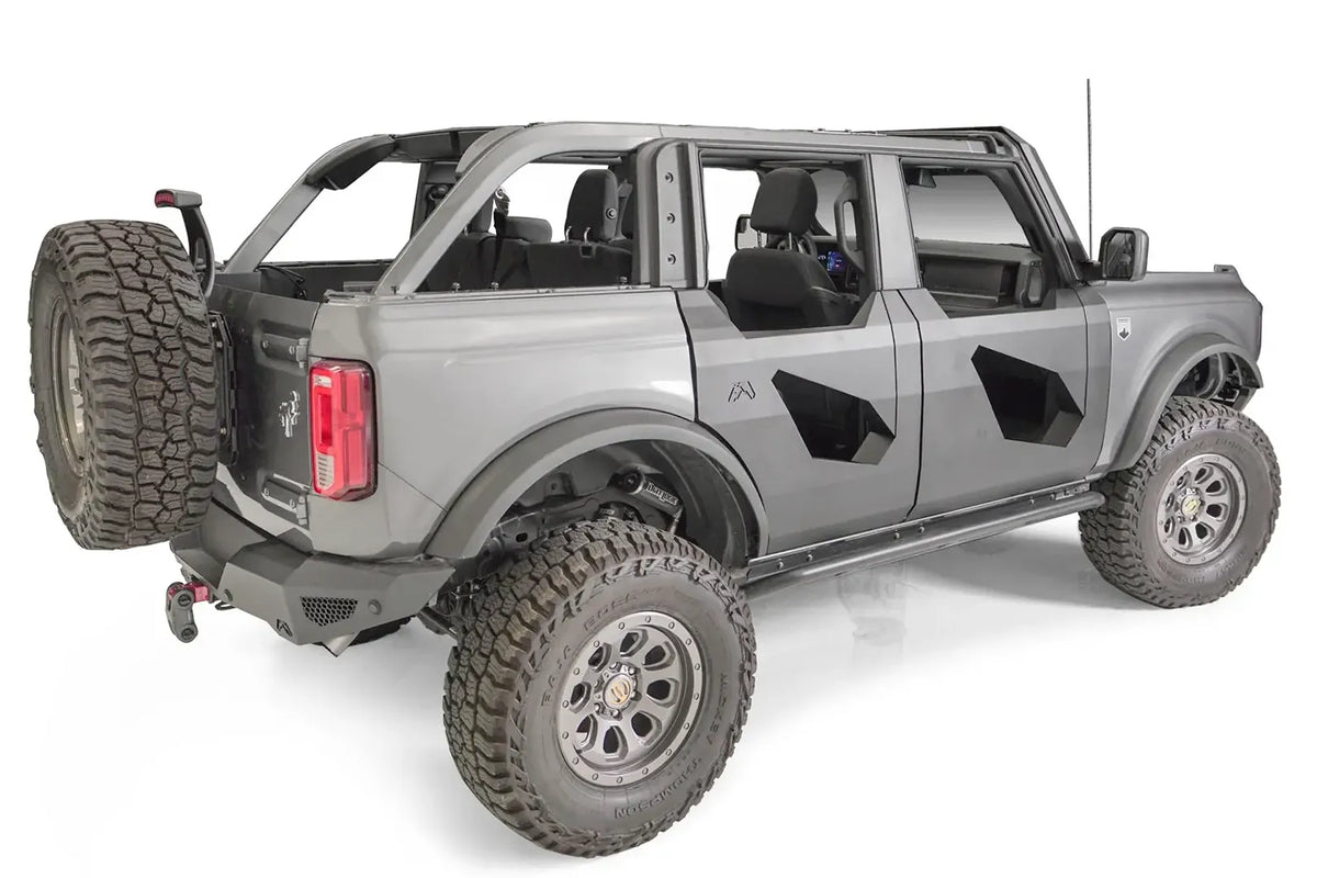 Fab Fours Trail Door Inserts on a gray four-door Ford Bronco, rear passenger-side view, showing the black steel inserts with angular cutouts on the front and rear doors