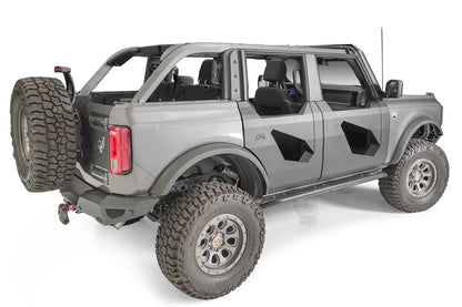 Fab Fours Trail Door Inserts on a gray four-door Ford Bronco, rear passenger-side view, showing the black steel inserts with angular cutouts on the front and rear doors