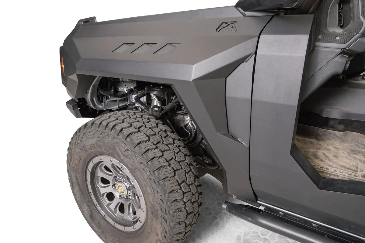 Close-up of Fab Fours front steel fender with three vent cutouts and Fab Fours logo on the driver side of a gray Ford Bronco
