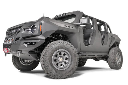 Fab Fours front steel fenders on a lifted gray Ford Bronco with doors removed, low driver-side front three-quarter view, with Fab Fours winch bumper and cowl light bar