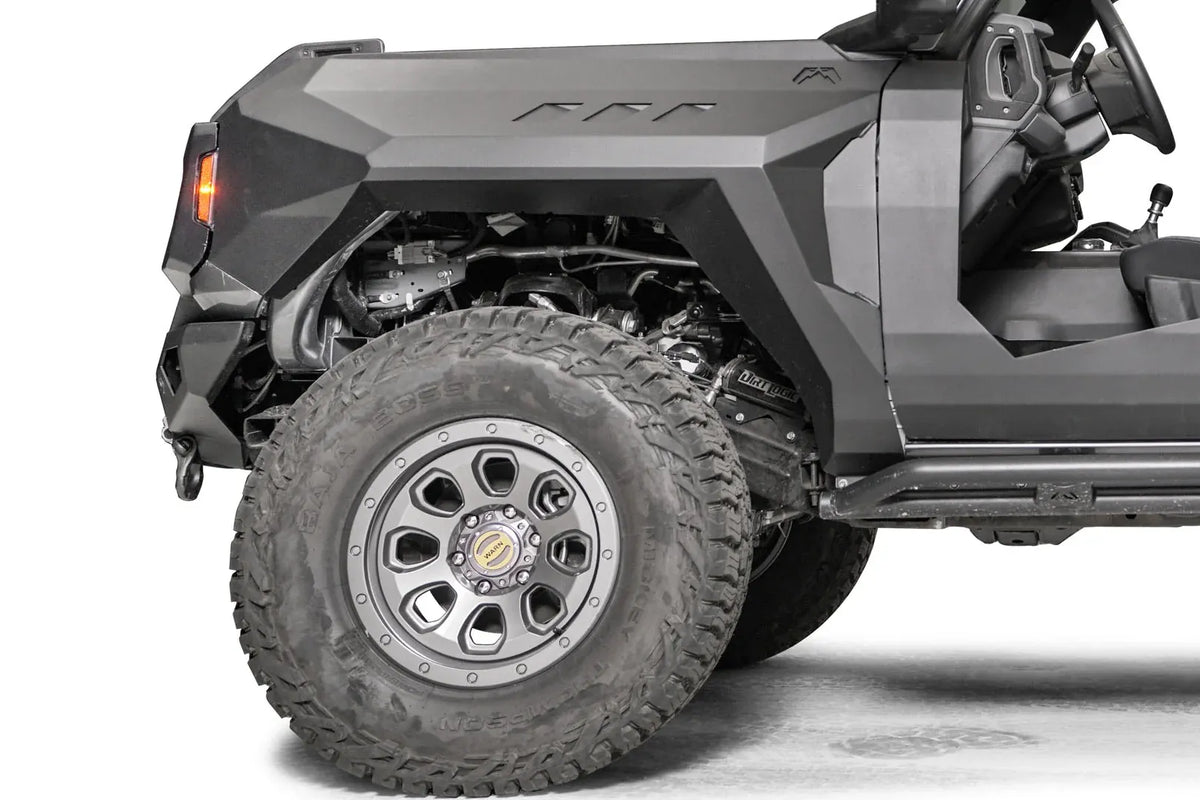 Fab Fours front steel fender with three vent cutouts and amber marker light on the driver side of a lifted gray Ford Bronco