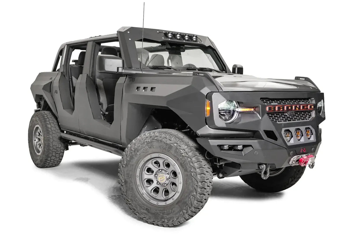 Fab Fours front steel fenders on a lifted gray Ford Bronco with doors removed, passenger-side front three-quarter view, with Fab Fours winch bumper
