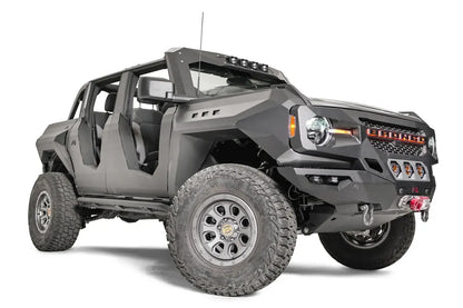 Fab Fours front steel fenders on a lifted gray Ford Bronco with doors removed, low passenger-side front three-quarter view, with Fab Fours winch bumper