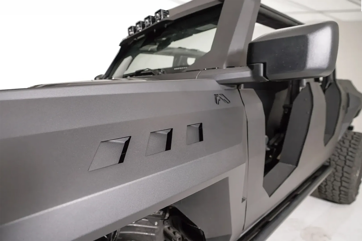 Close-up of the three vent cutouts and Fab Fours logo on a Fab Fours front steel fender on a gray Ford Bronco