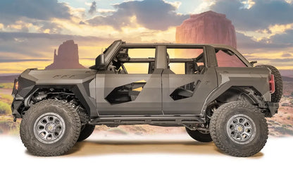 Fab Fours front and rear steel fenders on a lifted gray Ford Bronco with doors removed and Fab Fours body armor, driver-side profile view with desert background