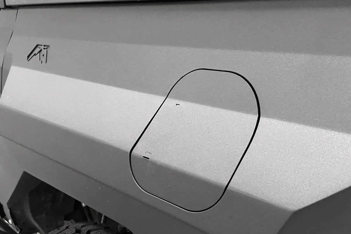 Close-up of the integrated fuel door, closed, in a Fab Fours rear steel fender on a Ford Bronco, with Fab Fours logo