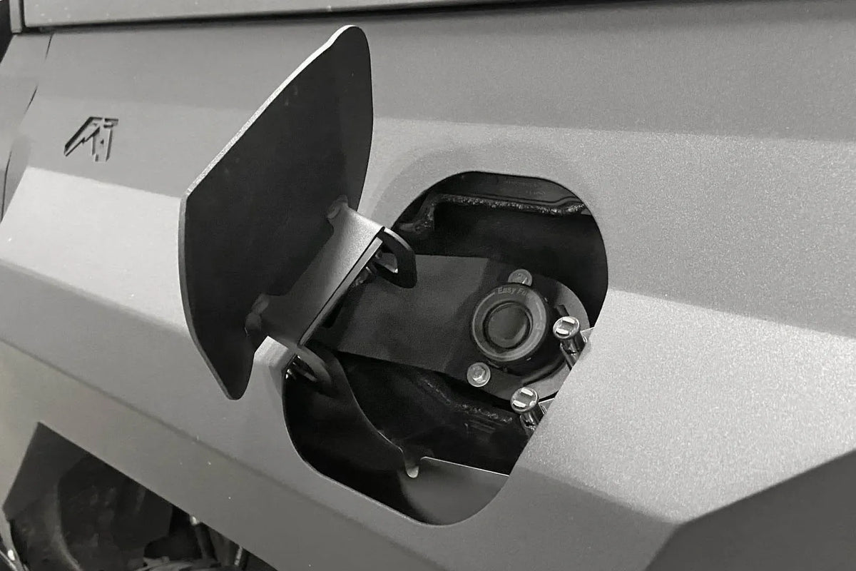 Close-up of the integrated fuel door, open, in a Fab Fours rear steel fender on a Ford Bronco, showing the capless fuel filler