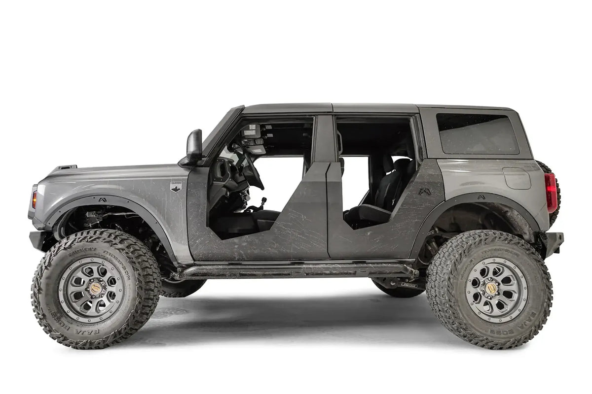 Fab Fours front and rear fender flares on a lifted gray Ford Bronco with doors removed, driver-side profile view