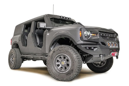 Fab Fours fender flares on a lifted gray Ford Bronco with doors removed, low passenger-side front three-quarter view, with Fab Fours front winch bumper