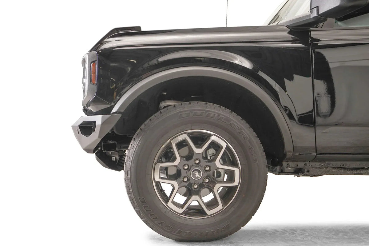 Fab Fours Vengeance front bumper on a black Ford Bronco, close-up of the driver-side bumper end, showing the angular end cap and tire clearance
