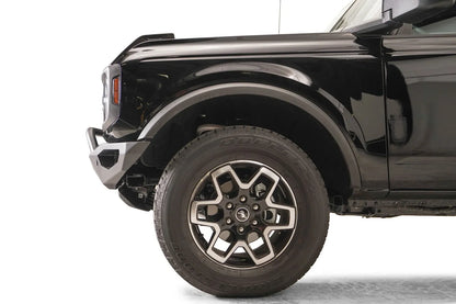 Fab Fours Vengeance front bumper with pre-runner guard on a black Ford Bronco, close-up of the driver-side bumper end, showing the pre-runner tube, end cap and tire clearance