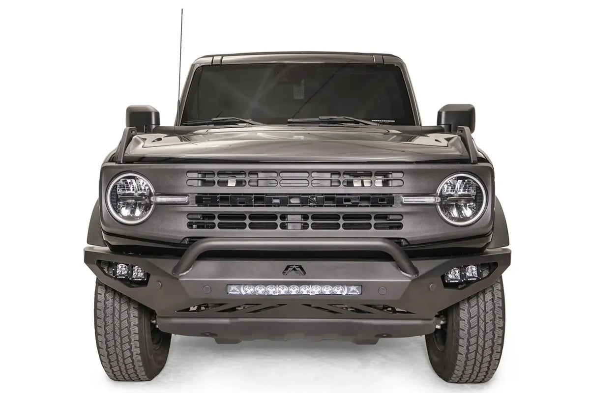 Fab Fours Vengeance front bumper with pre-runner guard on a black Ford Bronco, straight-on front studio view, showing the pre-runner hoop, center light bar and cube light pods