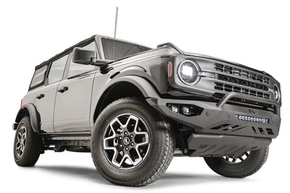 Fab Fours Vengeance front bumper with pre-runner guard on a black Ford Bronco, front passenger-side three-quarter studio view, showing the pre-runner hoop, light bar and skid plate
