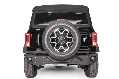 Fab Fours Vengeance rear bumper on a black Ford Bronco, straight rear view, with cube lights in each corner, license plate mount, and tailgate-mounted spare tire