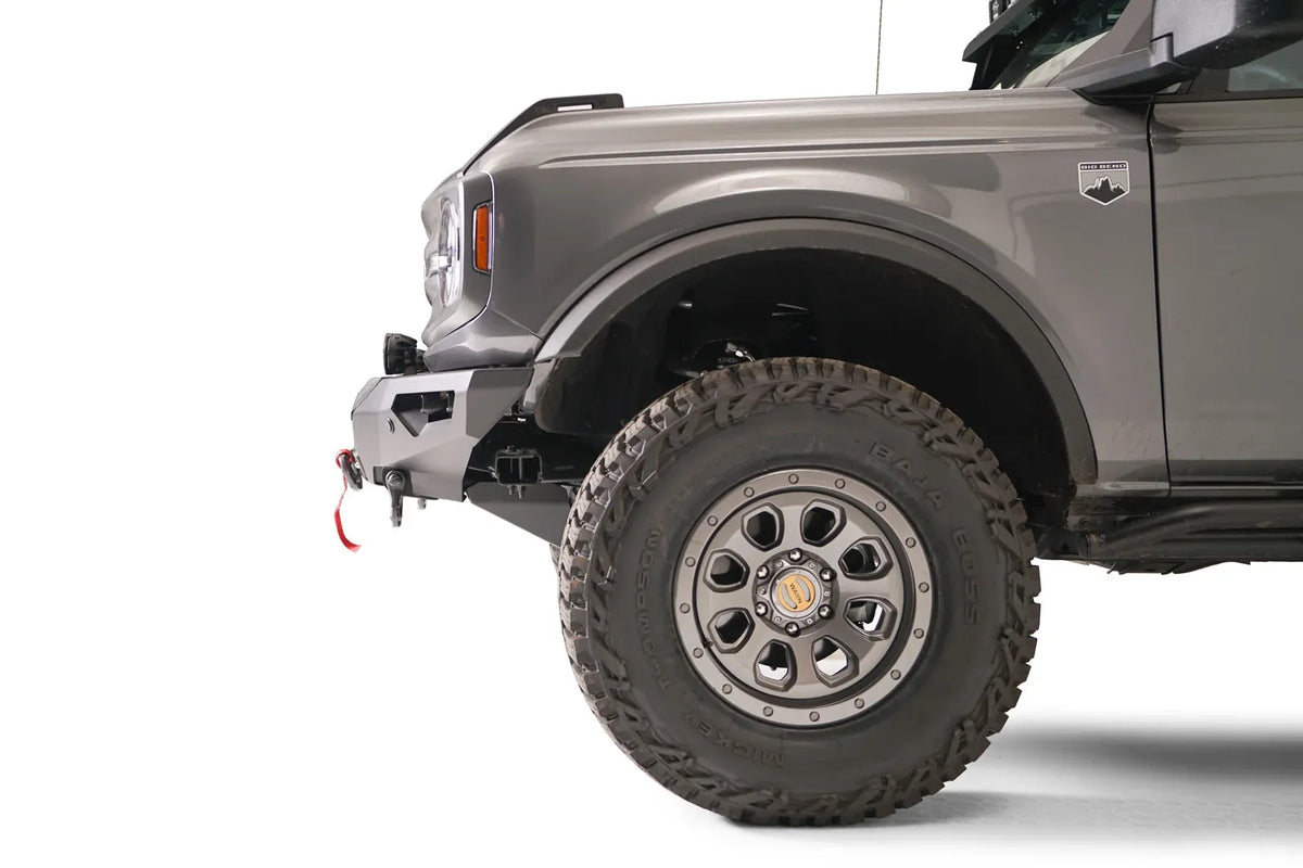 Fab Fours Lifestyle winch front bumper on a lifted gray Ford Bronco, driver-side profile view of the bumper end and front wheel