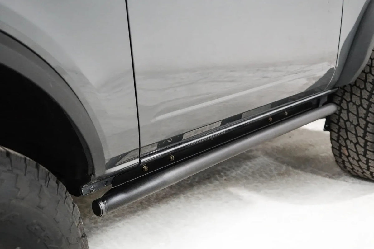 Close-up of the Fab Fours rock slider on a gray Ford Bronco, passenger side, showing the tube rail